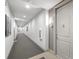 Long, neutrally decorated hallway with gray carpet, white walls, and doors leading to apartments at 145 Pier View St # 407, Charleston, SC 29492
