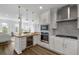 Modern kitchen with white cabinets, stainless steel appliances, wood countertops and view of the dining and living area at 145 Pier View St # 407, Charleston, SC 29492