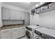 Well-equipped laundry room with modern washer and dryer, granite countertops, and ample storage cabinets at 145 Pier View St # 407, Charleston, SC 29492
