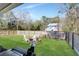 Large backyard featuring a fire pit, Adirondack chairs, a grill and wooded backdrop at 1543 Scott Hill Rd, James Island, SC 29412