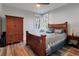 Bedroom featuring a wooden bed frame, armoire, and side table on hardwood flooring with natural light at 1543 Scott Hill Rd, James Island, SC 29412