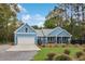 Charming home with black fence, front porch with seating, garage, and well-maintained lawn and landscaping at 1543 Scott Hill Rd, James Island, SC 29412