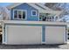 Detached two-car garage with white doors, a covered balcony above, and a blue shingled exterior at 1543 Scott Hill Rd, James Island, SC 29412