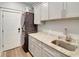 Practical laundry room with granite countertop, gray cabinets, and stacked washer/dryer at 1543 Scott Hill Rd, James Island, SC 29412
