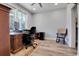 Home office with a traditional wooden desk, comfortable chair, and natural light from large windows at 1543 Scott Hill Rd, James Island, SC 29412