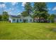 Large backyard with a well-kept lawn, solar panels, and charming houses in the neighborhood at 171 N Main St, Ridgeville, SC 29472