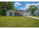 Inviting single-story home with teal shutters, solar panels, and a cozy front porch at 171 N Main St, Ridgeville, SC 29472