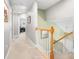 Bright hallway featuring neutral carpet and wood railings leading to an upstairs living space at 1813 Parkland Preserve Ln, Charleston, SC 29412