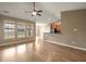 Bright living area with wood floors, three windows with blinds, and a view to the kitchen at 183 Cypress Forest Dr, Moncks Corner, SC 29461