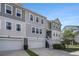 Beautiful exterior elevation of a townhouse featuring multi-car garages, neutral siding, and white trim at 185 Winding River Dr, Johns Island, SC 29455