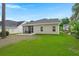 The backyard offers a screen porch, green grass and a concrete patio at 207 Brutus Ln, Summerville, SC 29485