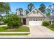 Charming home featuring a two-car garage, brick accents, and a well-maintained front yard at 207 Brutus Ln, Summerville, SC 29485