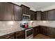 Modern kitchen featuring stainless steel appliances, granite countertops, and rich, dark wood cabinetry at 207 Brutus Ln, Summerville, SC 29485