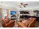 Open concept living room with adjacent kitchen, leather furniture, ceiling fan, and natural light at 207 Brutus Ln, Summerville, SC 29485