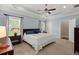 Bright main bedroom with tray ceiling, large windows, ceiling fan, and neutral carpet at 207 Brutus Ln, Summerville, SC 29485