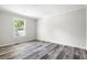 Empty bedroom showcasing a bright window with outside view and sleek wood floors at 208 General Moultrie Dr, Bonneau, SC 29431