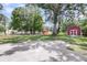Beautiful backyard with mature trees and large, red barn style outbuildings at 209 Pineview Dr, Goose Creek, SC 29445