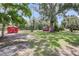 Large backyard featuring mature trees and several red barn style outbuildings at 209 Pineview Dr, Goose Creek, SC 29445
