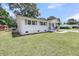 Charming white brick home boasts well-manicured lawn and classic architectural details under a sunny sky at 209 Pineview Dr, Goose Creek, SC 29445