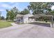 View of a well-maintained white brick home with a carport in a verdant, landscaped setting at 209 Pineview Dr, Goose Creek, SC 29445