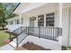 Inviting front porch features black railings and updated white brick, creating a welcoming entrance at 209 Pineview Dr, Goose Creek, SC 29445