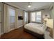 Cozy bedroom features a ceiling fan, multiple windows, and hardwood floors at 21 George St # 102, Charleston, SC 29401