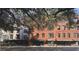 Brick condo building facade with mature trees on a sunny day at 21 George St # 102, Charleston, SC 29401