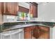 A kitchen sink features stainless steel appliances and gorgeous granite countertops, complemented by rich brown cabinets at 211 White Church Ln, Summerville, SC 29485