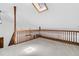 Carpeted loft area with natural light from a skylight and a stained wood safety railing at 211 White Church Ln, Summerville, SC 29485
