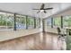 Sunroom features hardwood floors, many windows, a ceiling fan, and a slate tile bar counter with barstool at 211 White Church Ln, Summerville, SC 29485