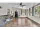 Sunroom features hardwood floors, many windows, a ceiling fan, and a slate tile bar counter with barstool at 211 White Church Ln, Summerville, SC 29485