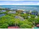 An aerial view of beach front homes nestled in mature trees with a view of the ocean and nearby beach at 22 Beachwood East, Isle of Palms, SC 29451
