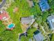 A high aerial view shows a home nestled in lush greenery and landscaping with a pool area and nearby ocean at 22 Beachwood East, Isle of Palms, SC 29451