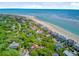 Breathtaking aerial view of homes near a sandy beach with clear blue ocean waters and lush greenery at 22 Beachwood East, Isle of Palms, SC 29451