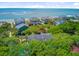 An aerial view shows a home nestled in mature trees with a view of the ocean and nearby beach homes at 22 Beachwood East, Isle of Palms, SC 29451