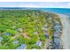 Beautiful aerial view of a coastal community with lush greenery, beachfront homes, and ocean views at 22 Beachwood East, Isle of Palms, SC 29451