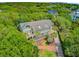 An aerial view shows a home with a brick driveway and landscaping nestled in mature greenery and palm trees at 22 Beachwood East, Isle of Palms, SC 29451