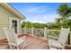 Inviting deck with wooden floor, white rocking chairs, and lush green views at 22 Beachwood East, Isle of Palms, SC 29451