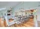 Open-concept dining area features a long table with seating for ten, flowing into the kitchen and living room at 22 Beachwood East, Isle of Palms, SC 29451