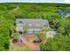 Lovely home surrounded by greenery and palm trees, featuring a balcony and brick walkway leading to the driveway at 22 Beachwood East, Isle of Palms, SC 29451