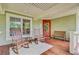 Inviting front porch with rocking chairs, bench, and view of the lush surroundings at 22 Beachwood East, Isle of Palms, SC 29451