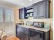 A kitchenette area featuring dark cabinets, granite countertops and a mini fridge at 22 Beachwood East, Isle of Palms, SC 29451