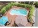 Aerial view of a private kidney-shaped pool surrounded by landscaped greenery and red brick patio at 22 Beachwood East, Isle of Palms, SC 29451