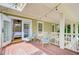 Covered outdoor patio featuring string lights, comfortable seating and an open doorway to the bright bedroom at 22 Beachwood East, Isle of Palms, SC 29451