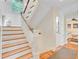 Elegant staircase with wood treads and white risers, accented by wainscoting on the walls at 22 Beachwood East, Isle of Palms, SC 29451