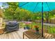 Relaxing back deck with umbrella, grill, wooden table and potted flowers overlooking the green backyard at 230 Azalea Ct, Moncks Corner, SC 29461