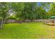 Large backyard with lush green grass, mature trees and a privacy fence at 230 Azalea Ct, Moncks Corner, SC 29461