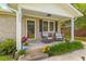 Inviting front porch with rocking chairs, flowers, and brick accents at 230 Azalea Ct, Moncks Corner, SC 29461