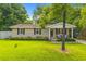 Charming brick home featuring a lush green lawn and inviting front porch with seating at 230 Azalea Ct, Moncks Corner, SC 29461