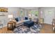 Comfortable living room area with a gray sofa, blue ottoman, and natural lighting at 230 Azalea Ct, Moncks Corner, SC 29461